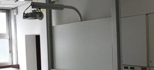 Kurzdistanz-Beamer an einem Wandarm über einem Whiteboard